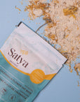 Satya Calendula Flower Oat Bath package with the contents spilled out.