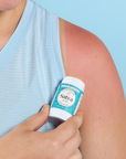 A person applying the Satya Multi Use Easy Glide Stick to their arm as sun aftercare.