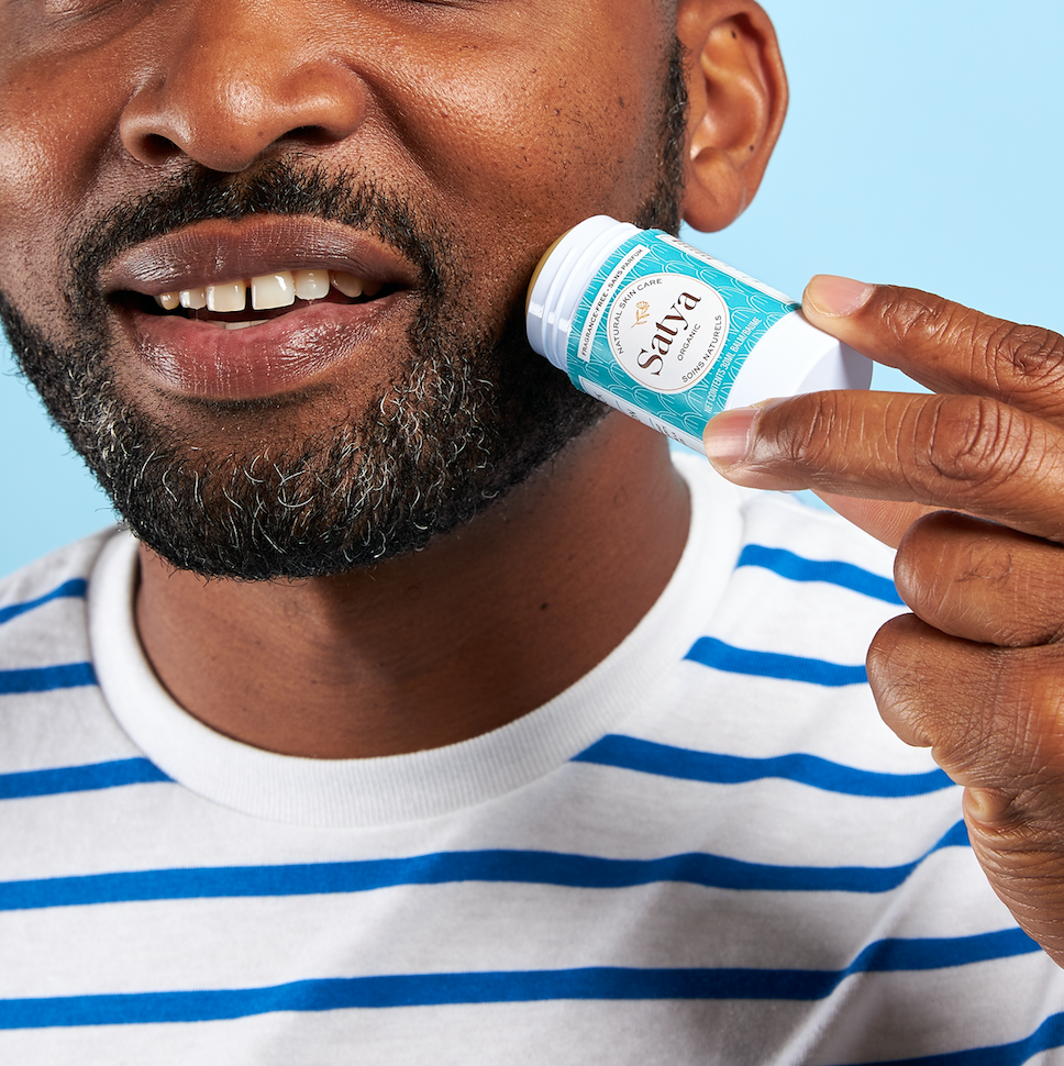 A person applying the Satya Multi Use Easy Glide Stick to their beard.